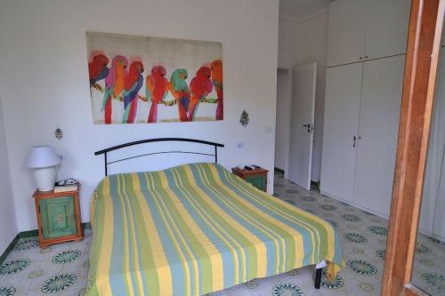 a bedroom with a bed and a painting of parrots at Casa Capolino in Scauri