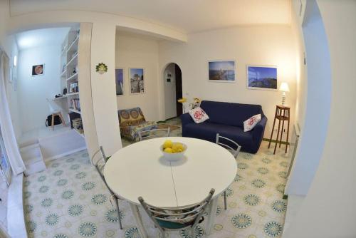 a living room with a white table and a blue couch at Casa Capolino in Scauri