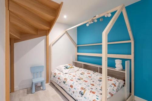 een kinderkamer met een hemelbed en een blauwe muur bij Superbe appartement avec parking gratuit in Lons-le-Saunier