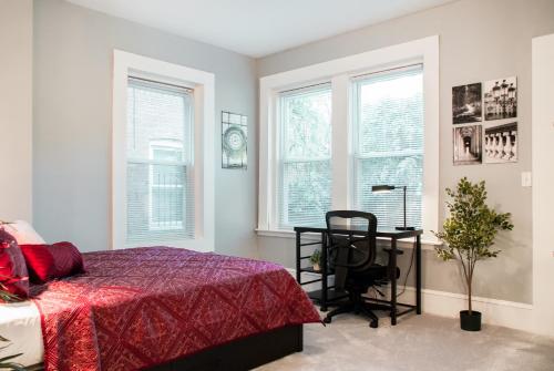 a bedroom with a bed and a desk and windows at Gorgeous 1BR Wooster Sq. apt. - wshr/dryr, parking in New Haven