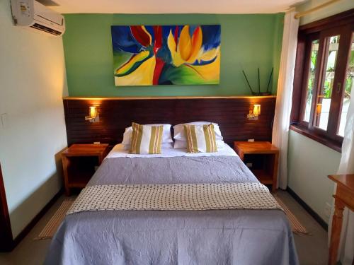 a bedroom with a bed and a painting on the wall at Casa Verde Río in Rio de Janeiro