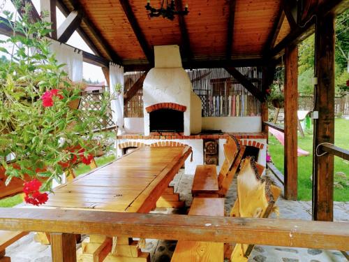 a wooden table and chairs in a patio with a fireplace at Cabana Rustic Balea in Cîrţişoara