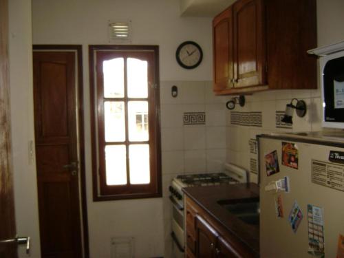una cocina con nevera y ventana en El Ebro en Villa Gesell