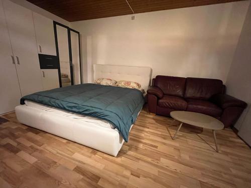 a bedroom with a bed and a couch at Private room for long term rent 1000-1200CHF per month in Bolligen