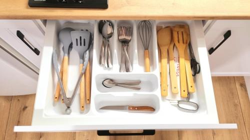 a drawer filled with utensils in a cabinet at Уютные апартаменты in Almaty