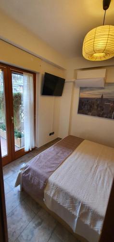 1 dormitorio con 1 cama grande y TV de pantalla plana en Home-like Apartment, en Roma