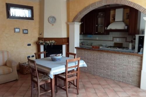 a dining room with a table and chairs and a kitchen at Country-House vista montagna in Foce