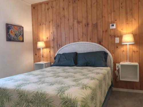 een slaapkamer met een bed met een houten muur bij Oleander Cottage- in the Heart of Flagler Beach and steps to the Beach! in Flagler Beach