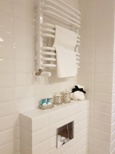 a white bathroom with white towels on a shelf at Apartamenty Kielce- Apartament Zacisze -Komfort przy Baseny Tropikalne, faktura, parking, centrum in Kielce