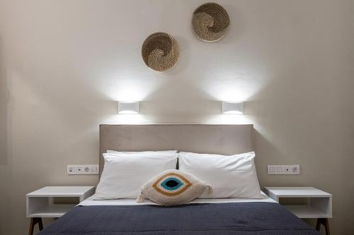 een slaapkamer met een bed met twee lampjes aan de muur bij Dilion Hotel in Parikia