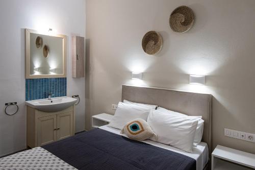Dormitorio pequeño con cama y lavamanos en Dilion Hotel, en Parikia