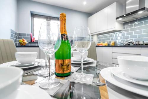 een fles champagne zittend op een tafel met glazen bij Isabel’s wing! A stunning 2 bedroom annex in Norwich