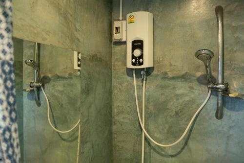 a bathroom with a soap dispenser on a wall at Art House at Chiangdao - Lake House in Chiang Dao