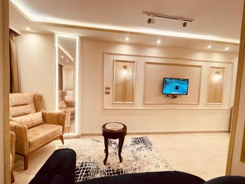 a living room with a couch and a tv on a wall at El mansour hotel apartmen 94 in Mansoura