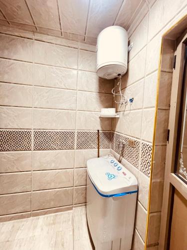 a bathroom with a toilet and a light on the wall at El mansour hotel apartmen 94 in Mansoura