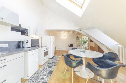 une cuisine et une salle à manger avec une table et des chaises dans l'établissement Suite Aubance - Maison Bossoreil, à Angers