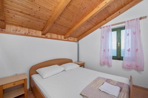 1 dormitorio con cama y ventana en House Mirta en Pašman