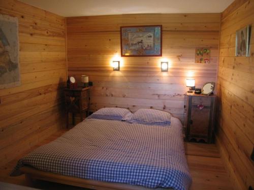 a bedroom with a bed in a wooden cabin at Les Mules in Combloux