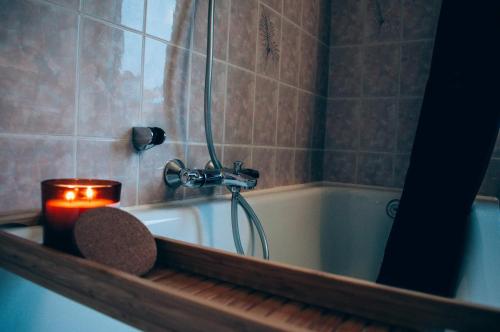 a candle in a bathroom with a bath tub at Vakantieappartement DE SPUIKOM in Ostend