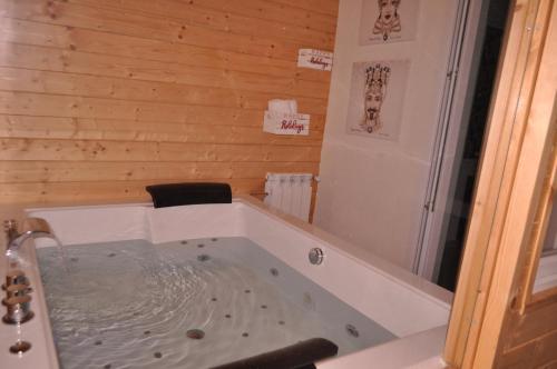 a bath tub in a room with a wooden wall at Agrihotel Croce Vallone in Biancavilla