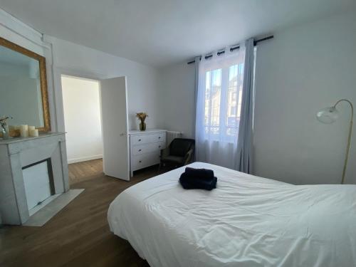 - une chambre blanche avec un lit et une cheminée dans l'établissement La Contemporaine - Belle maison en triplex - 058, à Rouen