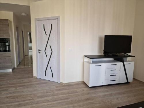 Zimmer mit einer Tür und einem TV auf einem Schrank in der Unterkunft Апартаменти Москва in Dobritsch