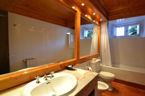 a bathroom with a sink and a toilet and a mirror at Paço de Calheiros - Turismo de Habitação in Ponte de Lima