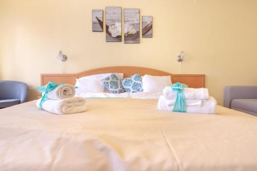 a bedroom with a bed with towels on it at Apartman In City Szombathely **** in Szombathely