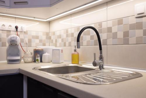 a kitchen counter with a sink in a kitchen at Apartman In City Szombathely **** in Szombathely