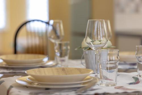 a table with plates and wine glasses on a table at Apartman In City Szombathely **** in Szombathely