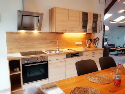 a kitchen with a table and a sink and a microwave at Ferienhaus Linder in Fischen