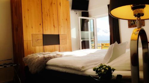 a bedroom with a bed and a window and a lamp at Ferienhaus Linder in Fischen