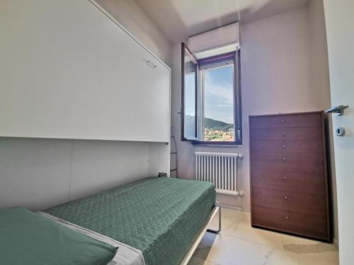 um pequeno quarto com uma cama e uma janela em Maison Olga - Incantevole Nuovo Trilocale Vista Mare con parcheggio em Borghetto Santo Spirito
