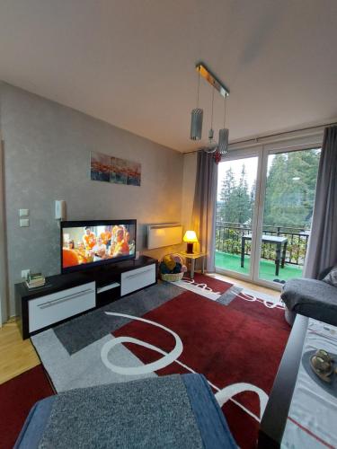 a living room with a large flat screen tv at Apartman 2 Zlaja Vlašić in Vlasic