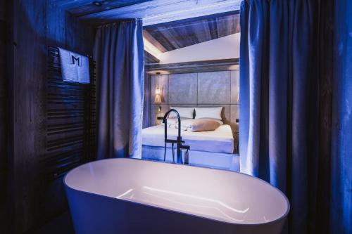 a bath tub in a room with a bed at Margarethenstein Boutique Hotel in Kaprun