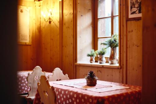 een eetkamer met een tafel en een raam bij Rifugio Malga Ra Stua in Cortina dʼAmpezzo