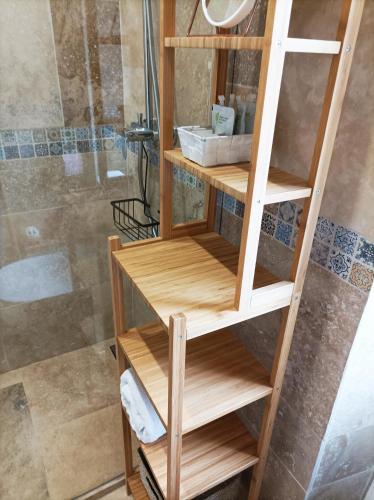 - une étagère en bois dans la salle de bains pourvue d'une douche dans l'établissement Le Salvator, à Cannes