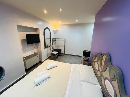 1 dormitorio con 1 cama blanca grande y paredes moradas en Appartamento Mellini, en Roma