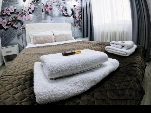 a bedroom with two beds with towels on them at New York Apartament in Suceava