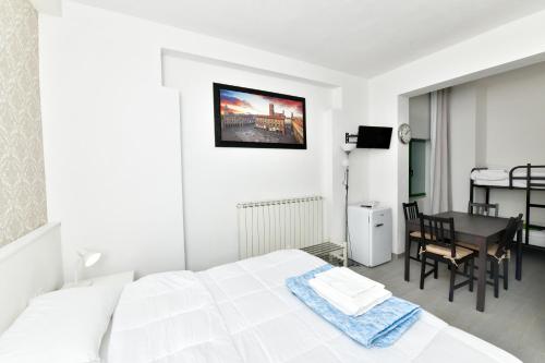 Dormitorio blanco con cama y mesa en A San Lazzaro Rooms, en San Lazzaro di Savena