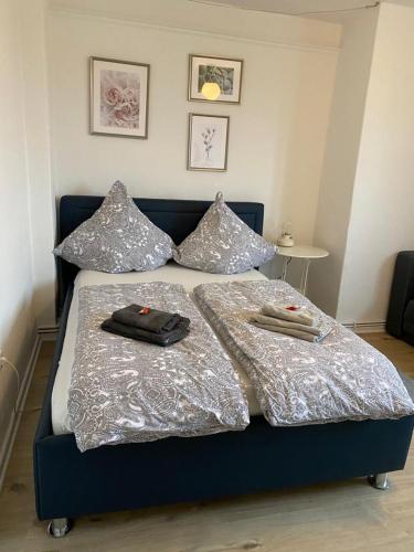 uma cama com lençóis e almofadas de prata em Tolle Ferienwohnung 34 qm Netflix Prime em Bochum