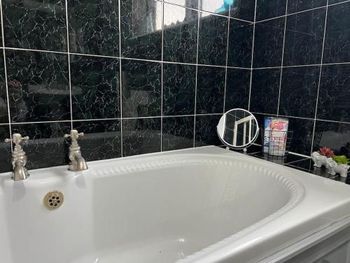een badkamer met een bad en een witte wastafel bij Tudor House - 6 guests -Off street parking -Quiet location - Secure Garden in Pemberton