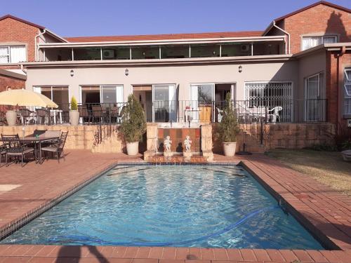 a swimming pool in front of a house at The Lakehouse BnB in Brakpan