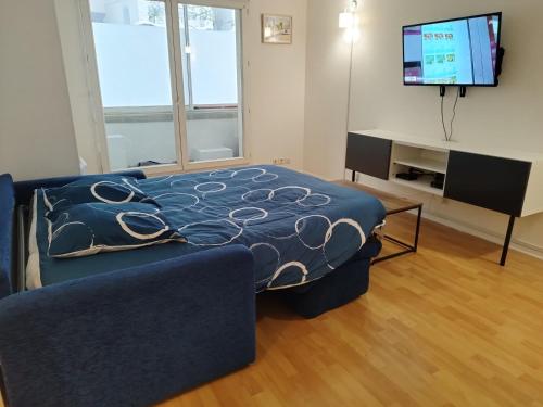 ein Wohnzimmer mit einem Bett, einem Sofa und einem TV in der Unterkunft Pantin appartement en rez-de-chaussée in Pantin