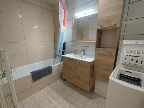 ein Badezimmer mit einer Badewanne, einem Waschbecken und einer Badewanne in der Unterkunft Pantin appartement en rez-de-chaussée in Pantin