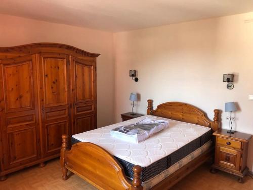 - une chambre avec un lit en bois et une armoire en bois dans l'établissement Joli appartement avec terrasse et jardin - vue sur montagne, à Bagnères-de-Bigorre