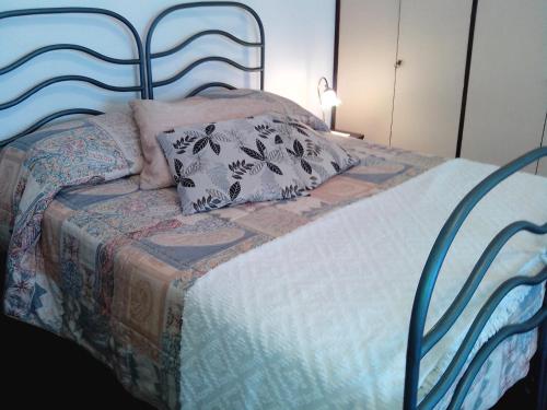 Bett mit blauem Kopfteil und Kissen darauf in der Unterkunft La Fusarella Villa Santoro in Vico Equense