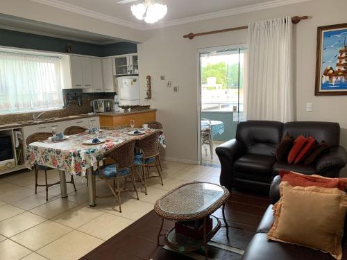 cocina y sala de estar con mesa y sofá en Residencial Atenas I, en Bombinhas