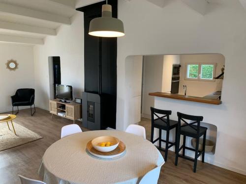 een woonkamer met een tafel en stoelen en een keuken bij Maison Noirmoutrine agréable de 3 chambres avec grand jardin in Le Grand Vieil