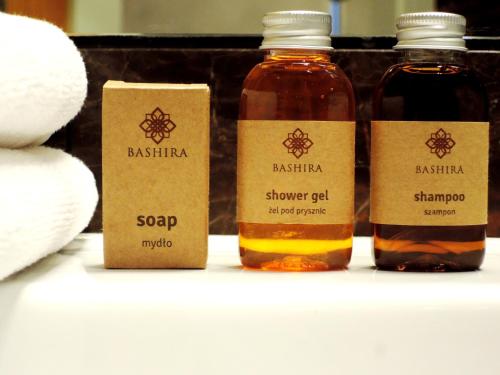 three bottles of soy sauce sitting on a shelf at SleepWell Apartments Ordynacka in Warsaw